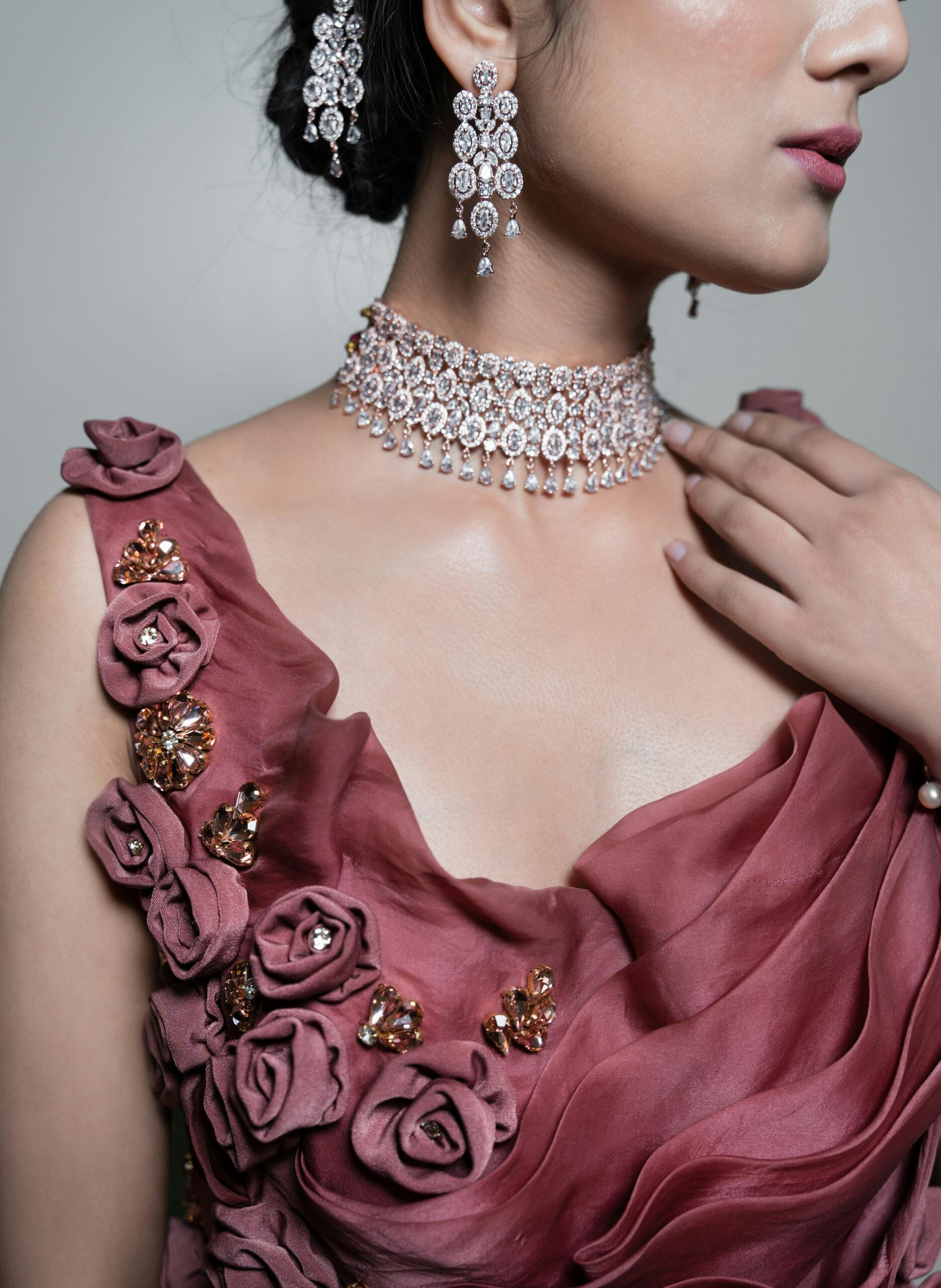 Close-up of an elegant woman adorned in luxurious earrings and necklace.